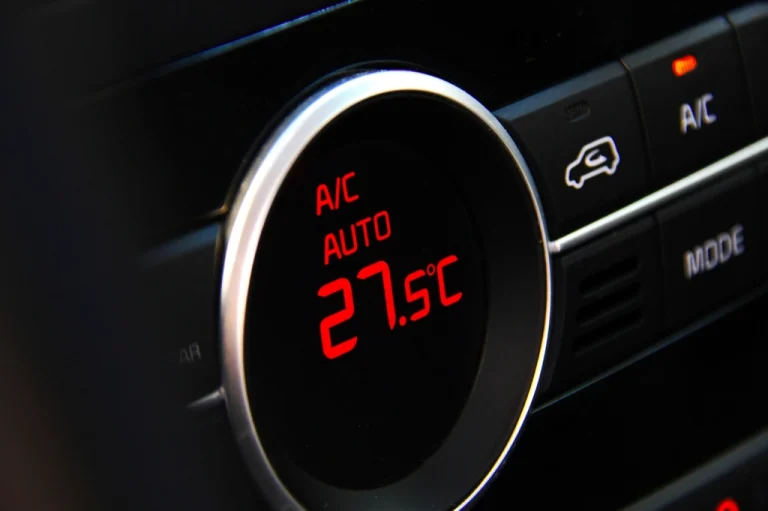 Car climate control display showing A/C auto for an air conditioning re-gas