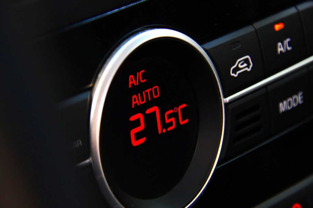 Car climate control display showing A/C auto for an air conditioning re-gas