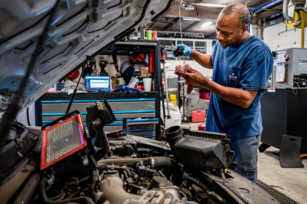 Busy car repair workshop with technicians working on vehicles
